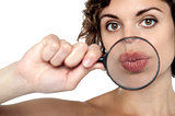 Lady holding magnifying glass in front of her lips