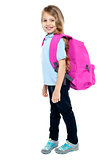 Happy little girl carrying school bag