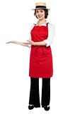 Pretty model in bakers apron presenting