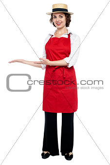 Pretty model in bakers apron presenting