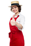 Young baker woman gesturing thumbs up