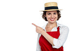 Cute woman in hat pointing sideways