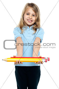 Cute kid in casuals holding colorful pencils