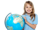 Young girl selecting holiday destination over globe