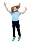 Delighted young girl jumping high in the air