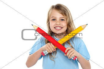 Charming school girl posing with big pencils