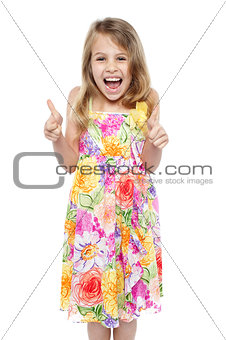 Excited young girl showing double thumbs up