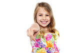 Portrait of a cheerful kid pointing towards you