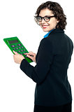 Young businesswoman using calculator
