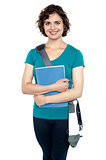 College student with stylish sling bag and notebook