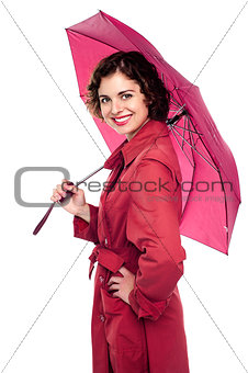 Glamorous woman standing under pink umbrella