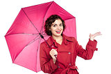 Woman with an umbrella reaches out to see if its raining