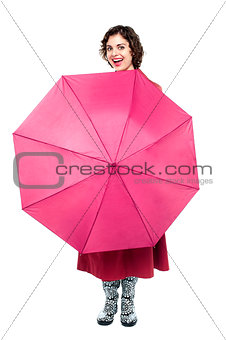 Cheerful woman being playful with umbrella