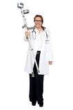 Happy doctor posing with crutches in hand