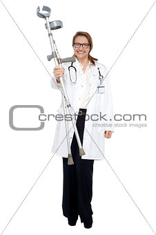 Happy doctor posing with crutches in hand