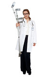 Serious faced doctor holding crutches