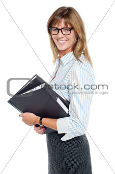 Smiling businesswoman carrying important files