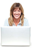 Pretty smiling lady working on laptop