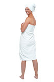 Hot woman in bath towel turning back and smiling