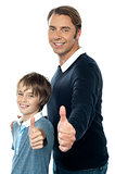 Confident father and son duo gesturing thumbs up