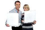 Middle aged couple holding white pizza boxes