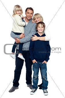 Affectionate family of four posing in winter outfits