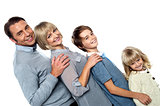 Cheerful family of four leaning backwards