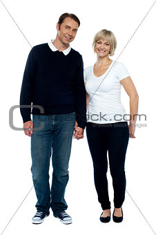 Middle aged couple posing with hand in hand