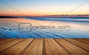 Beautiful low tide beach vibrant sunrise with wooden planks floor