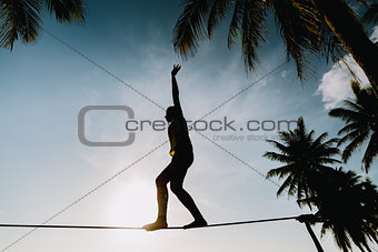 teenage girl  balancing on slackline with sky view