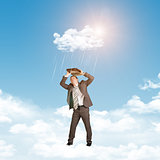 Businessman in suit standing on cloud and covered using briefcase from rain