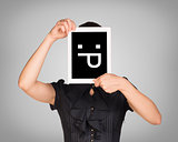 Girl in dress covered her face with tablet. On screen code smiley