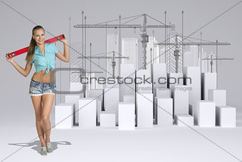 Worker holding builders level on shoulders. White cubes with tower cranes