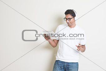 Indian guy playing music with tablet