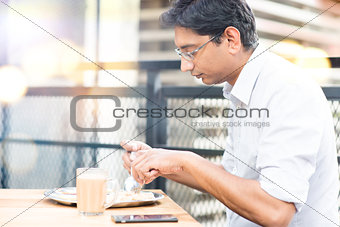 A man eating food at cafeteria.