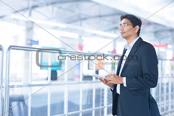 Man using tablet pc at train station