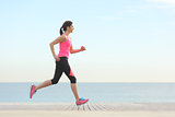 Side view of a woman running on the beach