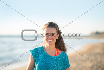 Portrait of happy fitness young woman on beach in evening
