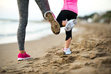 Closeup on healthy mother and baby girl workout on beach in the 