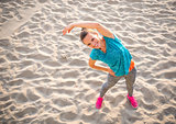 Fitness young woman stretching on beach