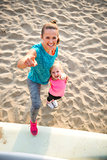 Portrait of healthy mother and baby girl pointing while on beach