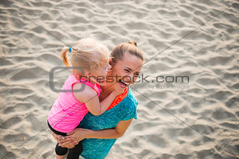 Healthy mother and baby girl on beach having fun time