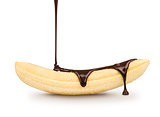 dark chocolate is poured on the ripe banana on a white backgroun