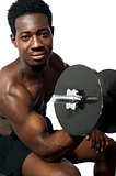 Powerful young man lifting weights