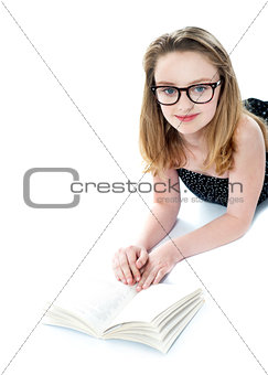 Girl wearing eyeglasses and reading book