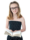 Cute little girl standing with an open book