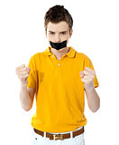 Angry boy with masking tape on mouth.