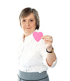 Woman showing heart shaped pink paper