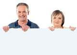 Old age couple holding blank banner ad