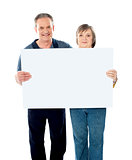 Husband and wife displaying advertising board